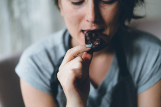 Mulher comendo barra de chocolate