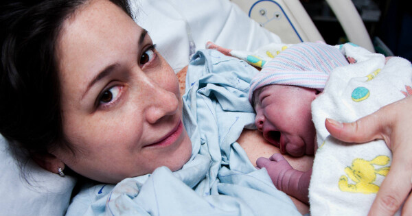 Mulher amamentando filho recém-nascido no hospital