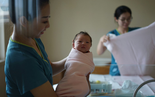 Mulher chinesa segurando um bebê recém-nascido