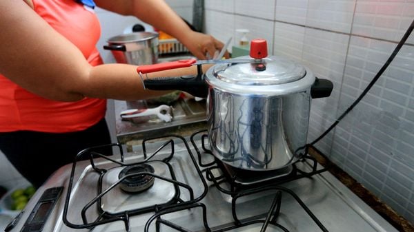 Mulher cozinhanndo feijão em panela de pressão