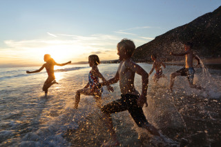 Crianças correndo para o mar da praia