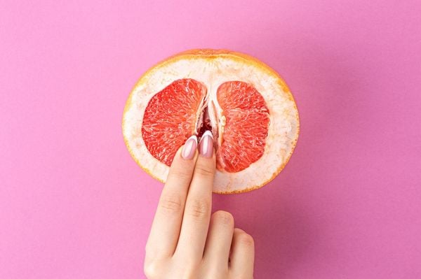 Dedos femininos em uma toranja