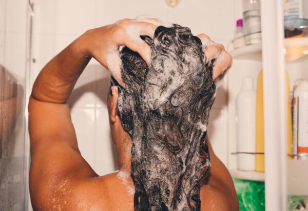 Mulher lavando o cabelo com shampoo