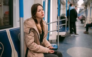 mulher solitária olhando para o nada no metrô