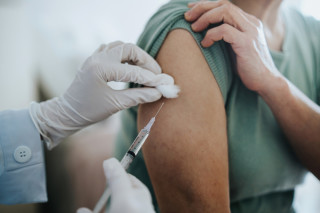 Médico aplicando vacina no braço em paciente