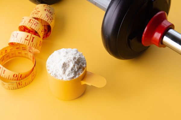 Scoop de creatina em um fundo amarelo