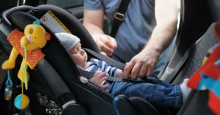 Pai colocando bebê conforto no carro