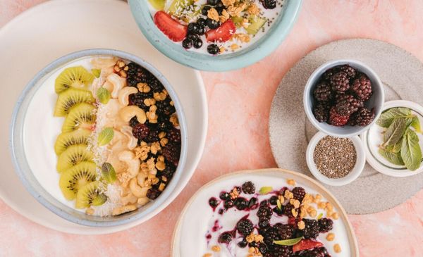 Visão de cima de uma mesa com quatro potes com diferentes tipos de alimentos