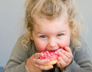 Menina comendo uma rosquinha