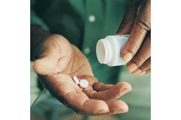 Homem colocando pílulas na mão