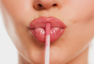 Mulher aplica gloss nos lábios - Foto: Shutterstock
