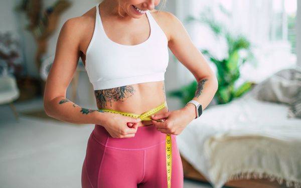mulher medindo a barriga com fita métrica