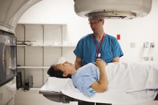 médico falando com paciente que está deitada em maca em uma sala de exame raio x