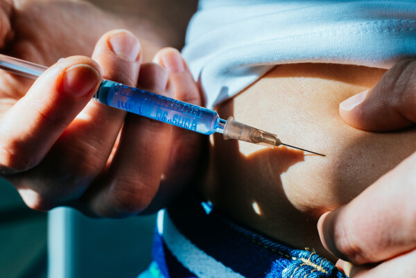 Pessoa aplicando injeção de Wegovy na barriga para tratar a obesidade