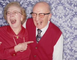 Casal de idosos sorrindo com próteses
