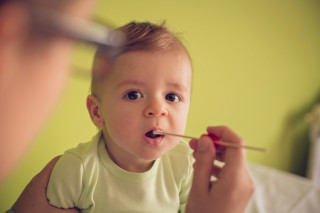 Médico colocando cotonete na boca de um bebê
