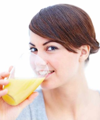 Mulher bebendo copo de bebida laranja