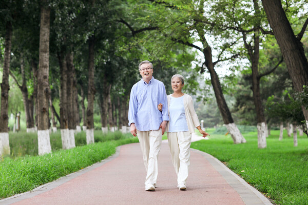 Casal de homem e mulher idosos caminhando em um parque