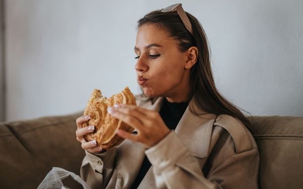 mulher comendo um sanduíche
