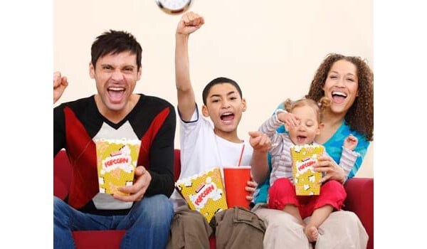 família assistindo tv e comendo pipoca