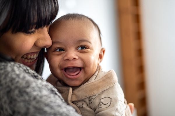 Bebê sorrindo no colo da mãe