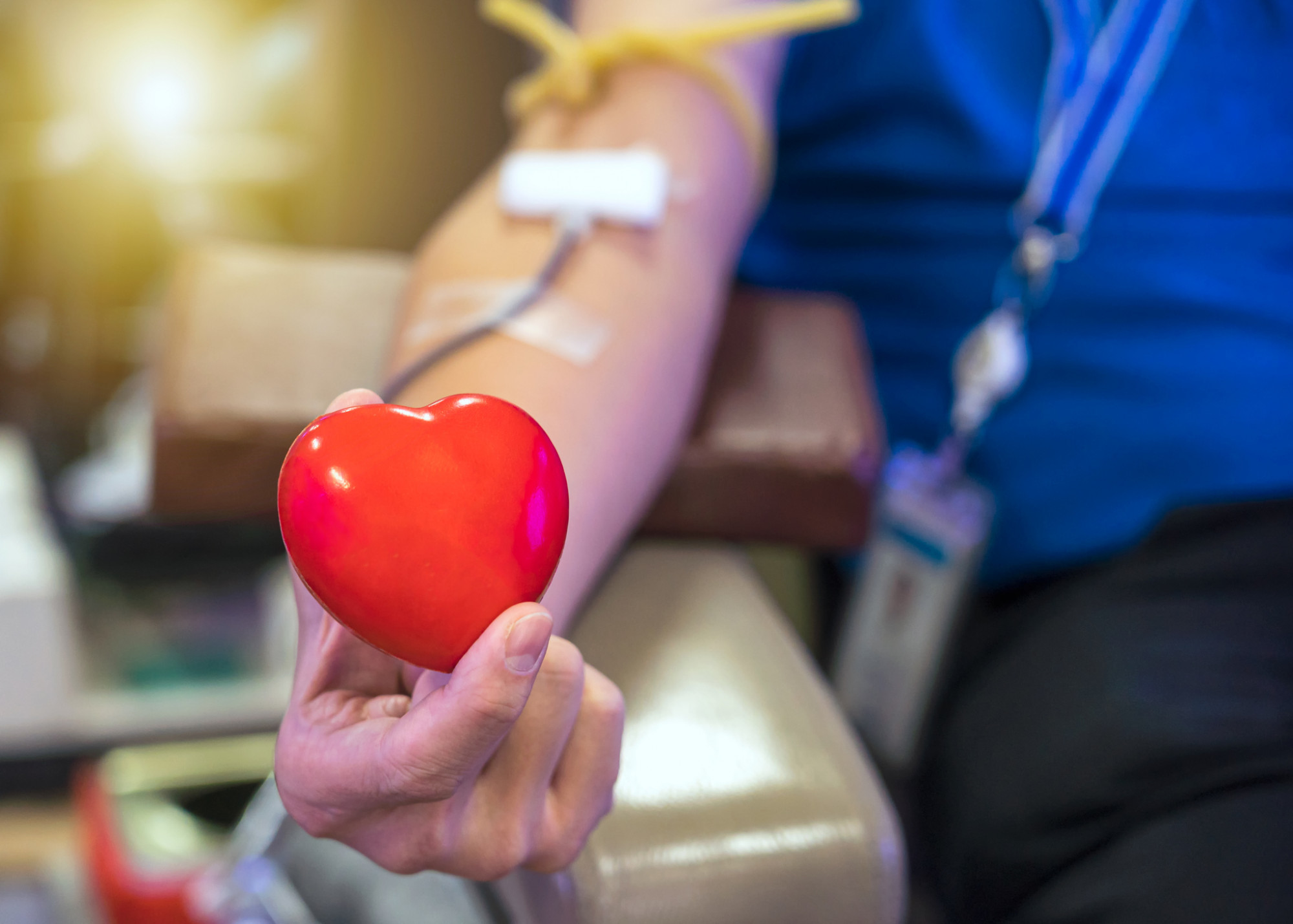 Homem doando sangue segurando um coração