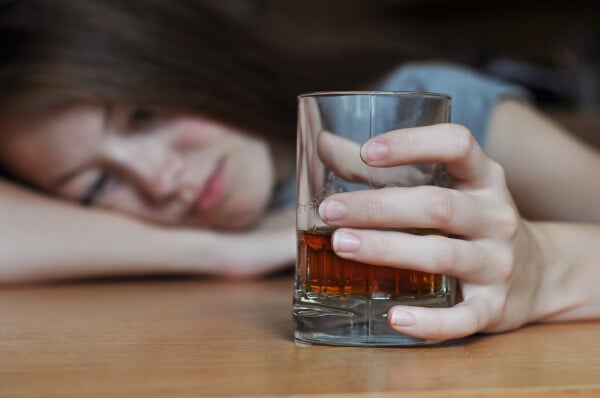 Mulher deprimida com copo de bebida alcoolica na mão