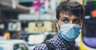 Homem com máscara médica se protege de coronavírus em Hong Kong