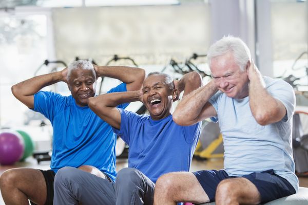Três idosos fazendo exercício físico