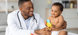Médico pediatra examina um bebê de aproximadamente 6 meses em um consultório