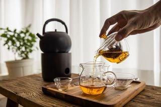 Mão de uma pessoa preparando chá oolong