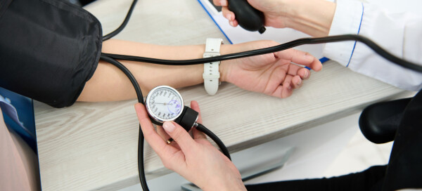 Mulher grávida tem a pressão arterial aferida no consultório médico