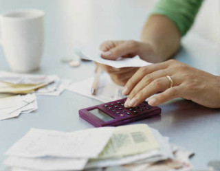 mulher fazendo contas na calculadora