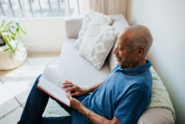 Homem sênior lendo livro em casa