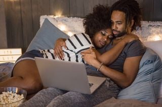 Casal jovem assistindo filme no quarto