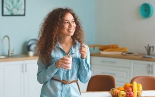 menina comendo iogurte na cozinha