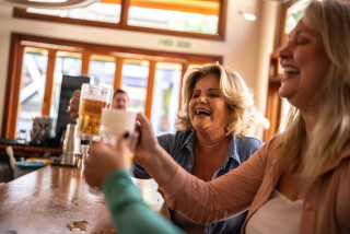 Gravida tomando cerveja em um bar ao lado de amiga