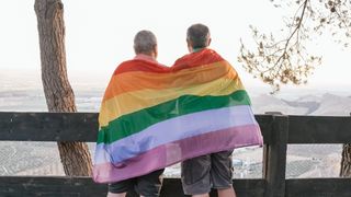 Um casal de idoso com a bandeira LGBTQIAP+