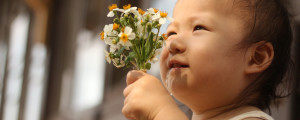 Bebê segurando buquê de flores