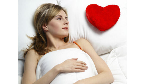 mulher dormindo com um travesseiro de coração