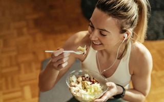 mulher comendo um pote de salada