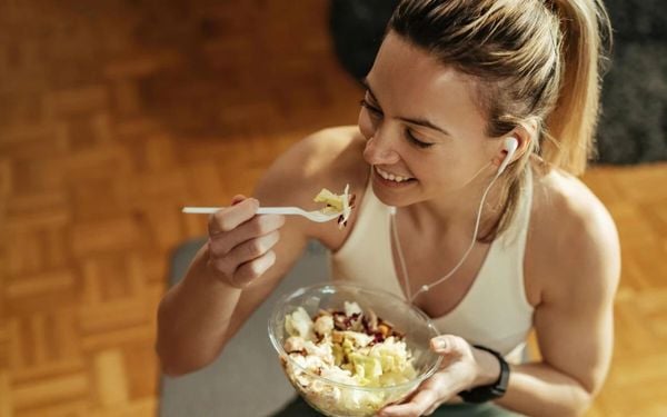 mulher comendo um pote de salada