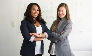 Duas mulheres em frente a uma lousa