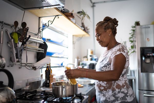 Mulher de meia-idade cozinhando macarrão em panela