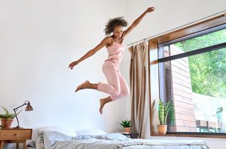 Mulher pulando na cama depois de acordar