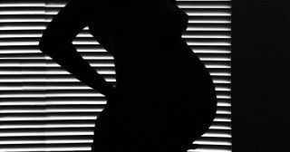 Sombra de mulher grávida contra a luz