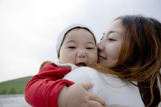 Mãe com filha no colo