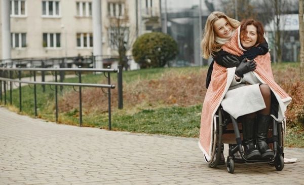 Duas mulheres, amigas, se abraçando em um parque