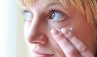 Mulher passando creme no rosto - foto: Getty Images