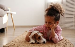 criança abraçando cachorro
